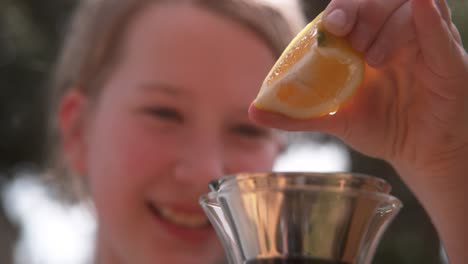 young girl squeezes lemon quarter to make lemonade one hand 1000 fps phantom