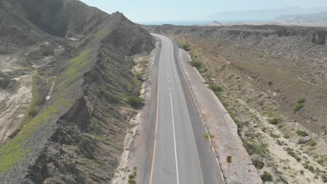 Toma-Aérea-De-Una-Hermosa-Carretera-Costera-Vacía-A-Lo-Largo-De-La-Costa-Del-Mar-árabe-De-Pakistán