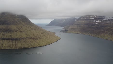 aerial view kunoy and haraldssund fjord on borðoy island, faroe - dramatic dark clouds flying in the air