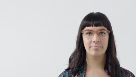 portrait-of-young-hipster-woman-looking-serious-at-camera-wearing-stylish-glasses-on-white-background-isolated