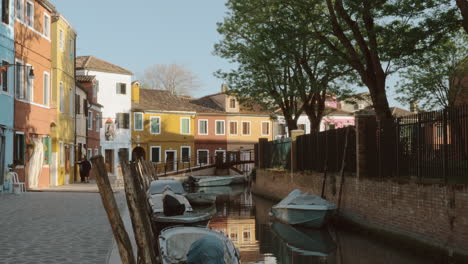 canal with boats and coloured houses in burano island italy