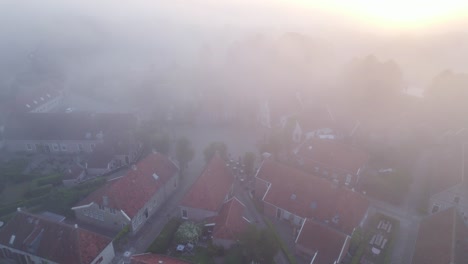 Flying-over-famous-fort-Bourtange-with-dense-fog-during-sunrise,-aerial