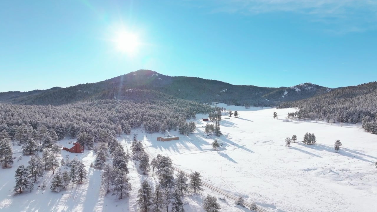 Paesaggio invernale natalizio incantato, versante montano ghiacciato, prato e valle innevati, drone aereo, Evergreen Colorado USA, cielo azzurro e soleggiato, National Forest, Evergreen Meadows, Three Sisters, Denver Park, vista verso l'alto
