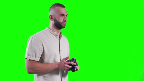 young photographer using camera and taking photos against green background