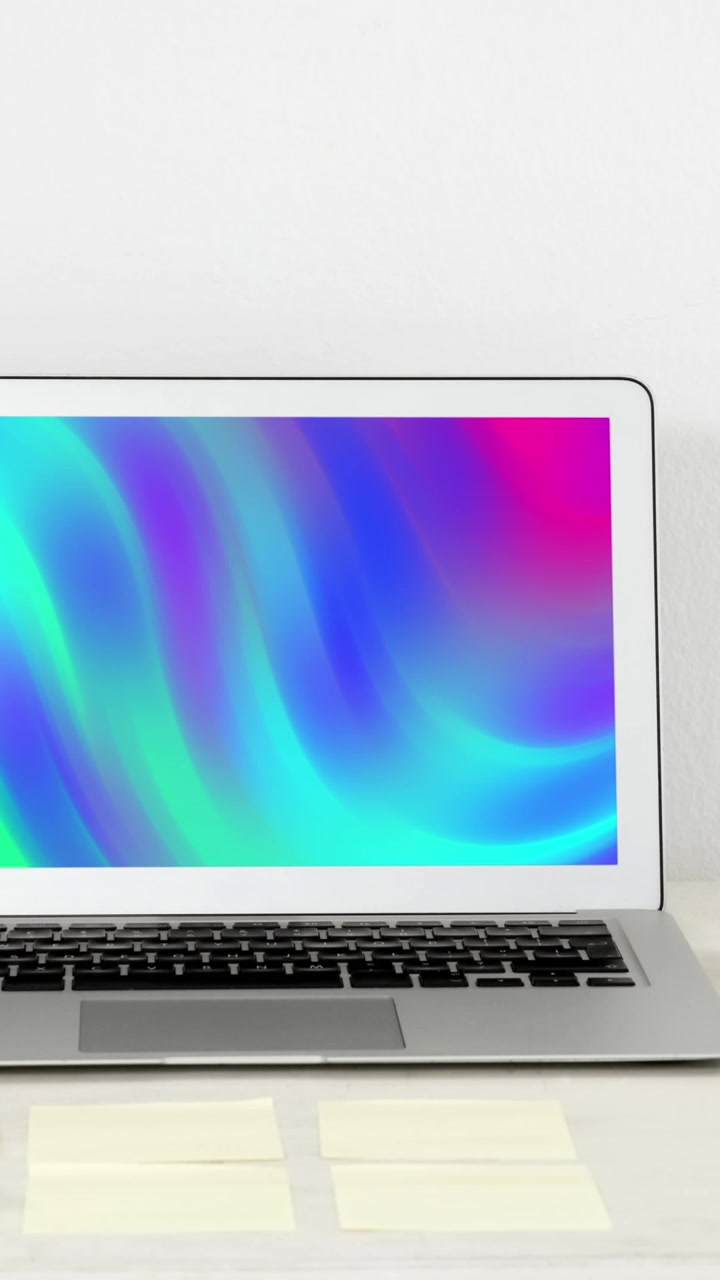 Animazione di laptop con forme colorate in movimento sullo schermo sulla scrivania