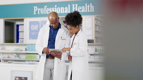 dos farmacéuticos usando una tableta digital juntos
