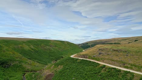 drohnen-luftaufnahmen von moorlandschaften in den tälern von yorkshire, die sich langsam einen fußweg hinauf bewegen