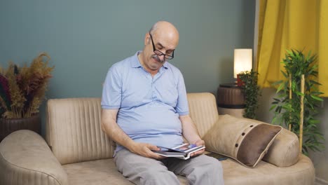 The-old-man-looking-at-the-family-album-is-depressed.