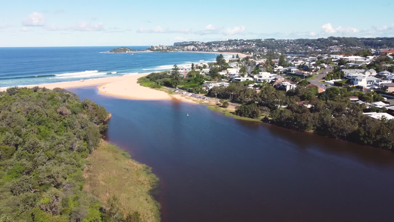 dron aéreo disparado a través del lago wamberal lagoon con viviendas residenciales playa terrigal naturaleza viajes turismo costa central nsw australia 4k