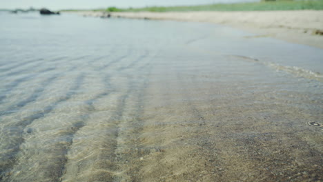 calm waves hitting shoreline sandy sand beach island vacation resort sunny sun day exotic yoga meditation background ambient relaxing 4k water wet bubble fish sand castle loop pacific close up shallow