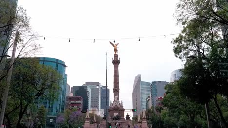 daily traffic on paseo de la reforma in the mexican capital city. angel of independence monument. mexico.