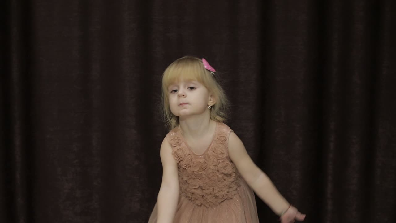 feliz niña de tres años hacer caras y bailar. niño rubio lindo