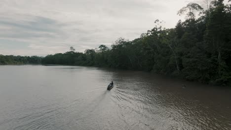 turista montando una canoa móvil está conduciendo sobre una laguna en la selva amazónica de ecuador