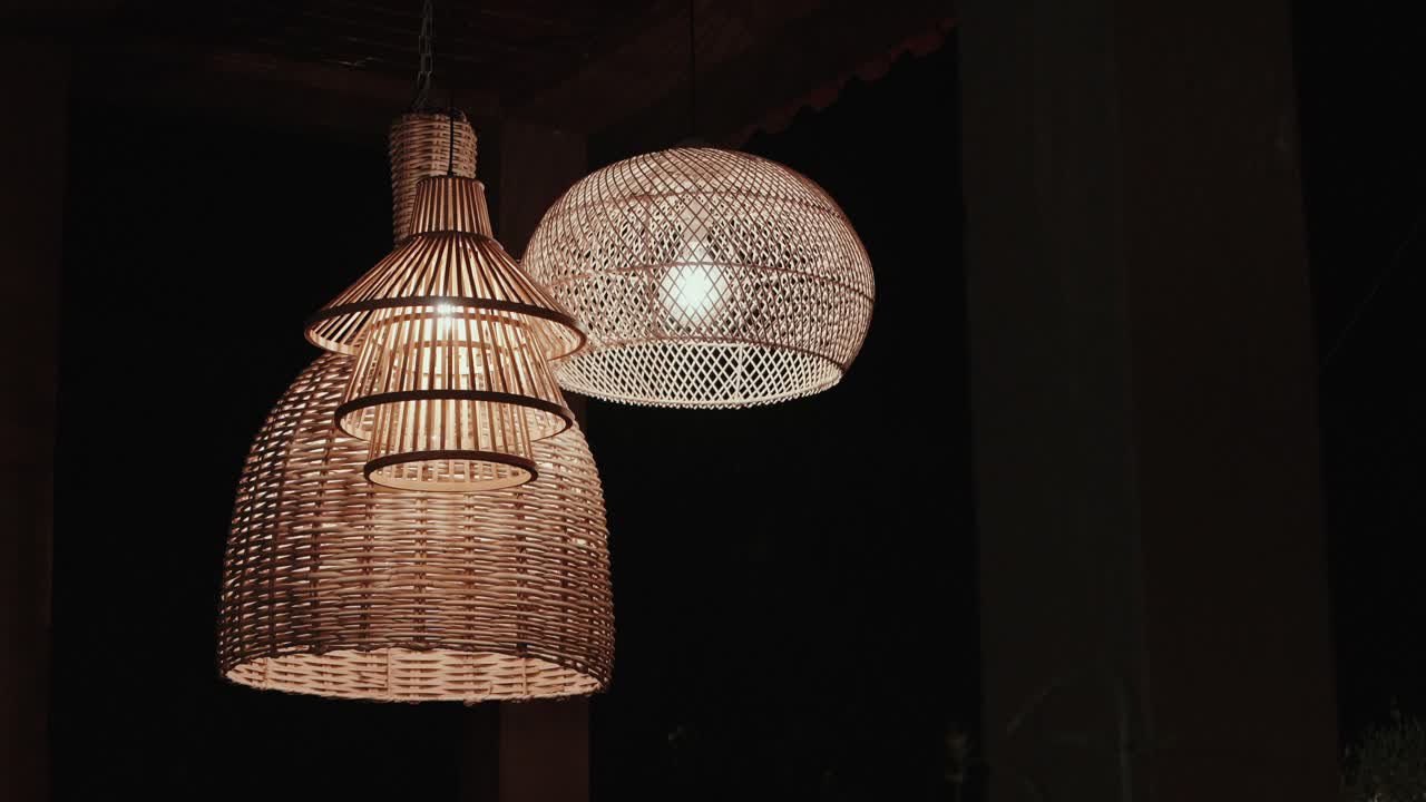 Close up of wicker pendant lights glowing warmly in evening ambiance