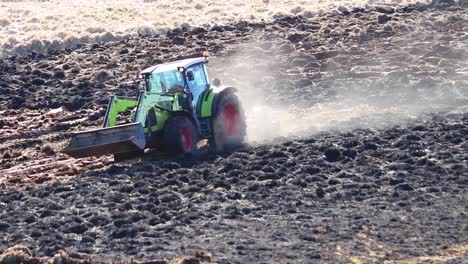 a farmer ploughing a new field after a grass burn to make ploughing easier