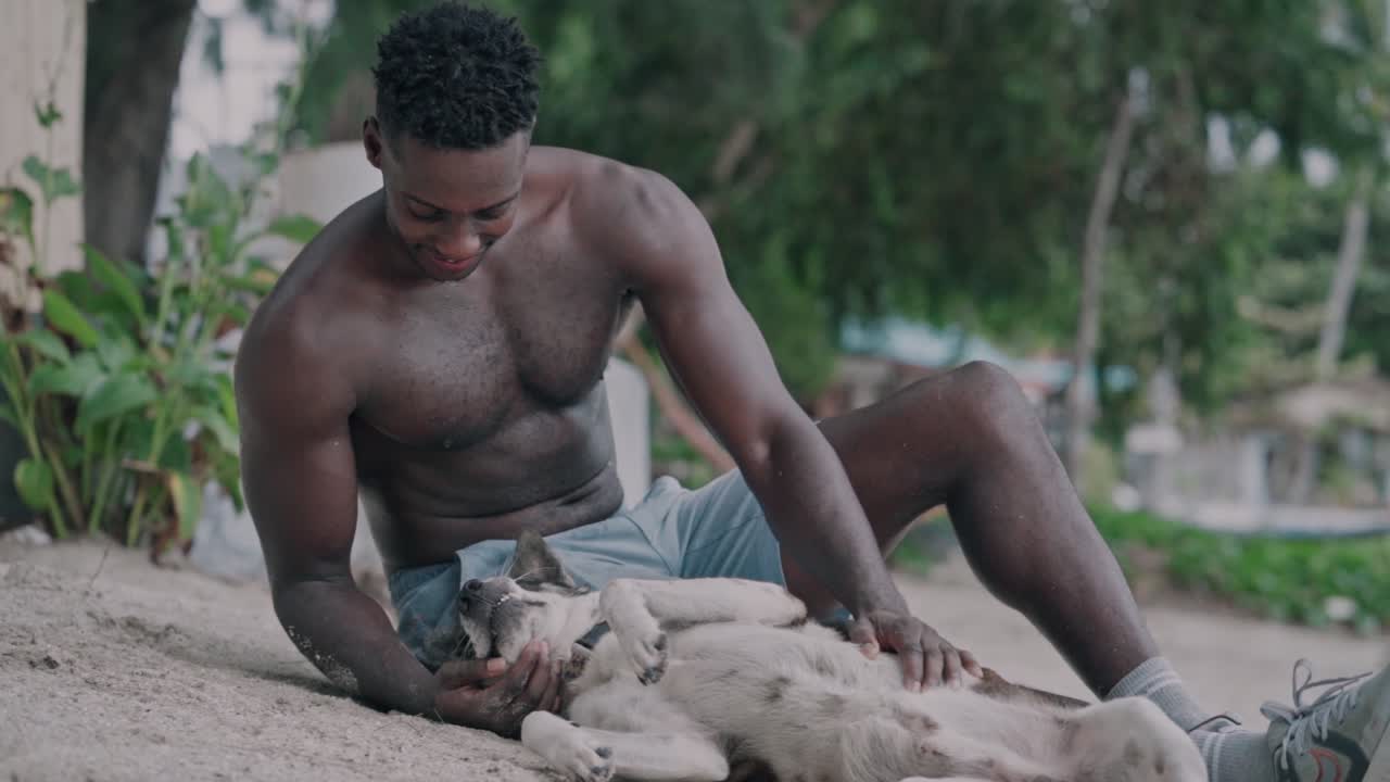 Uomo felice che accarezza un cane su una spiaggia sabbiosa
