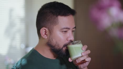 man drinking matcha latte