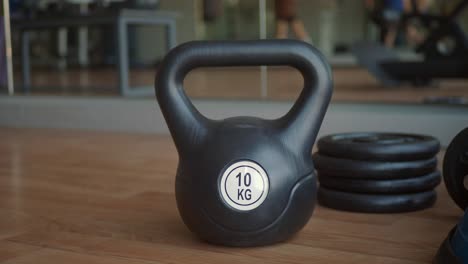 black kettlebell and weight plates in a gym