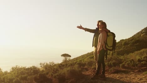 active senior couple pointing in forest