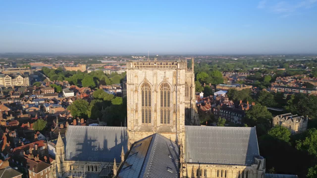 Aerial drone point of interest shot rotating clockwise around the central tower of York Minster, showcasing the Gothic cathedral’s architecture from above in York, England