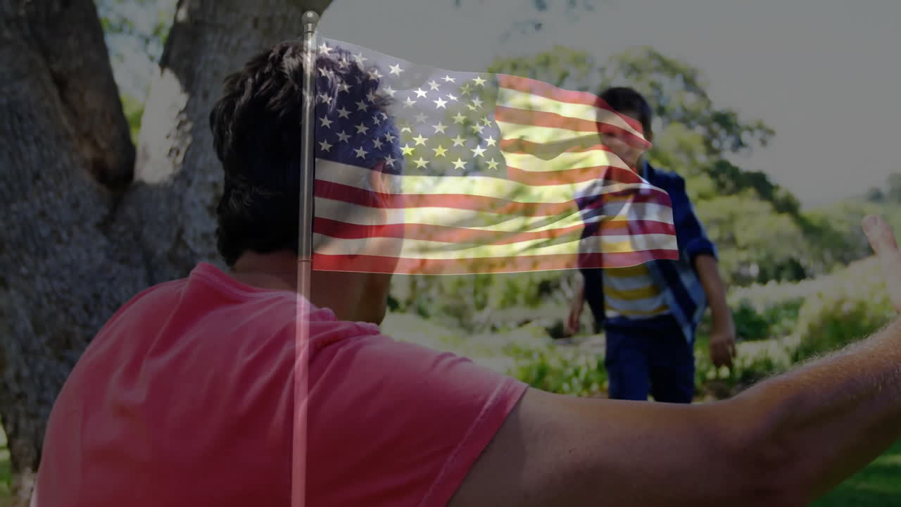 Playing in park, father and daughter with animation of American flag overlay