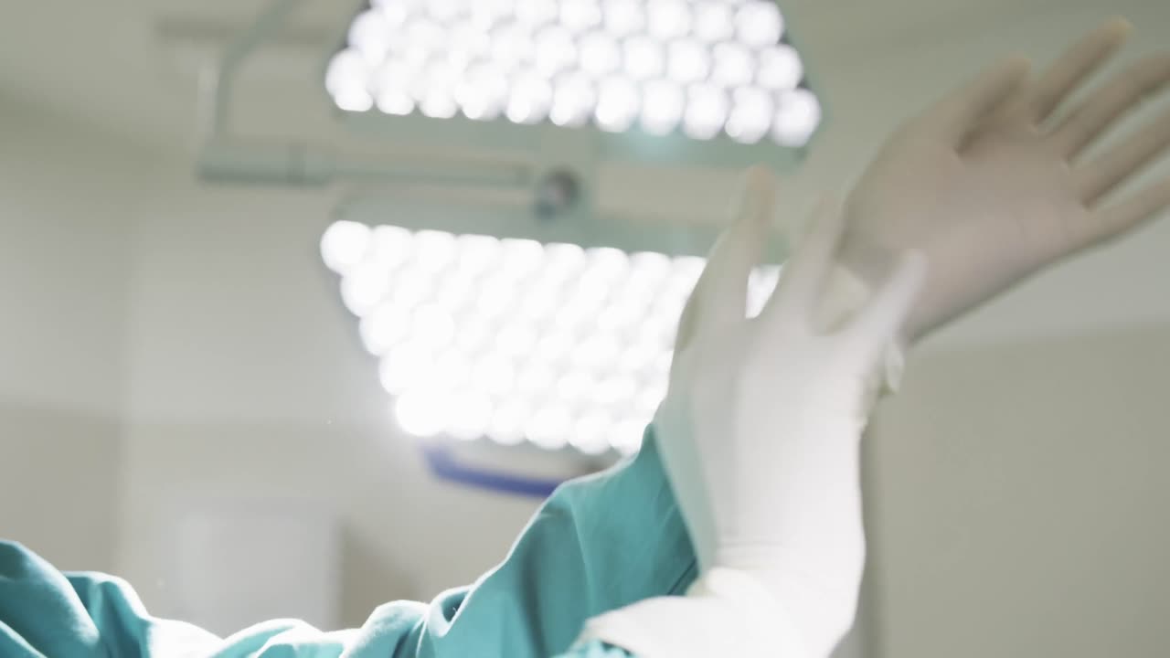 Doctora afroamericana con guantes en el quirófano del hospital, en cámara lenta