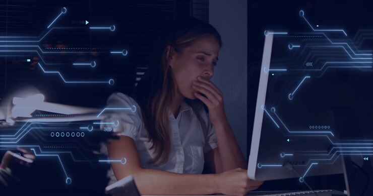 IT-professionel taster på tastaturet, aktiverer et kredsløbsoverlejring, der pulserer på skærmen, og gaber af træthed.