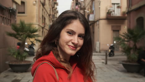 young girl smiling and looking at the camera in the street