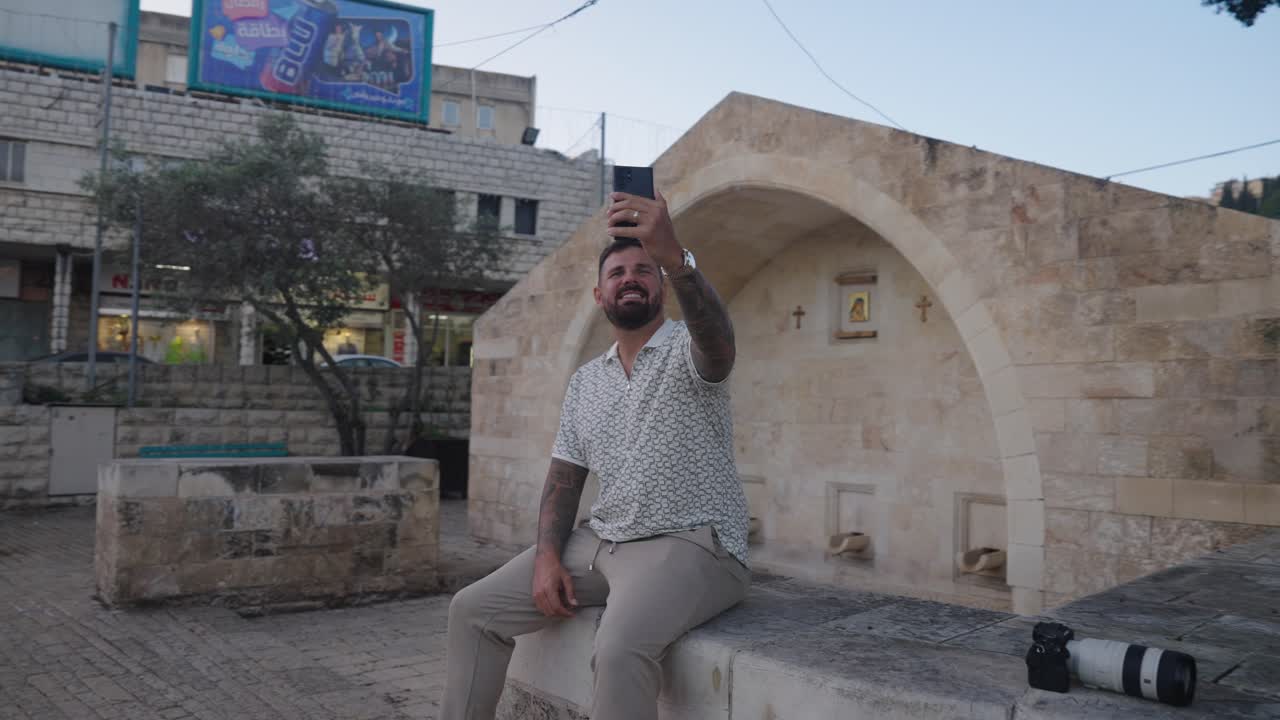 Male tourist takes selfie in front of Mary's Well in old town Nazareth