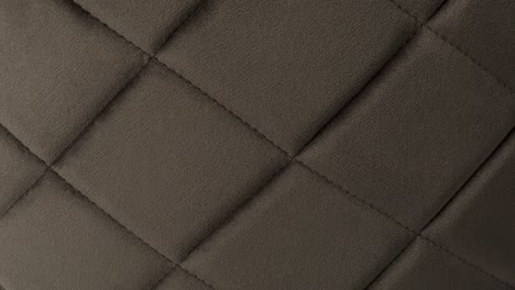 camera slowly zooms in on light brown tufted velvet texture in a photography studio