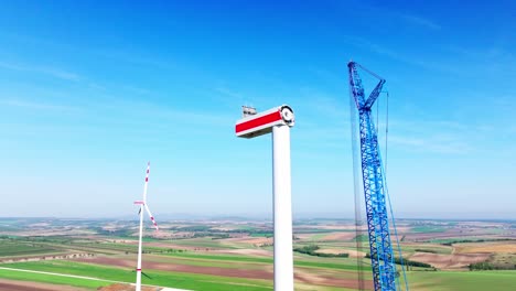 wind turbine under construction in idyllic landscape - aerial drone shot