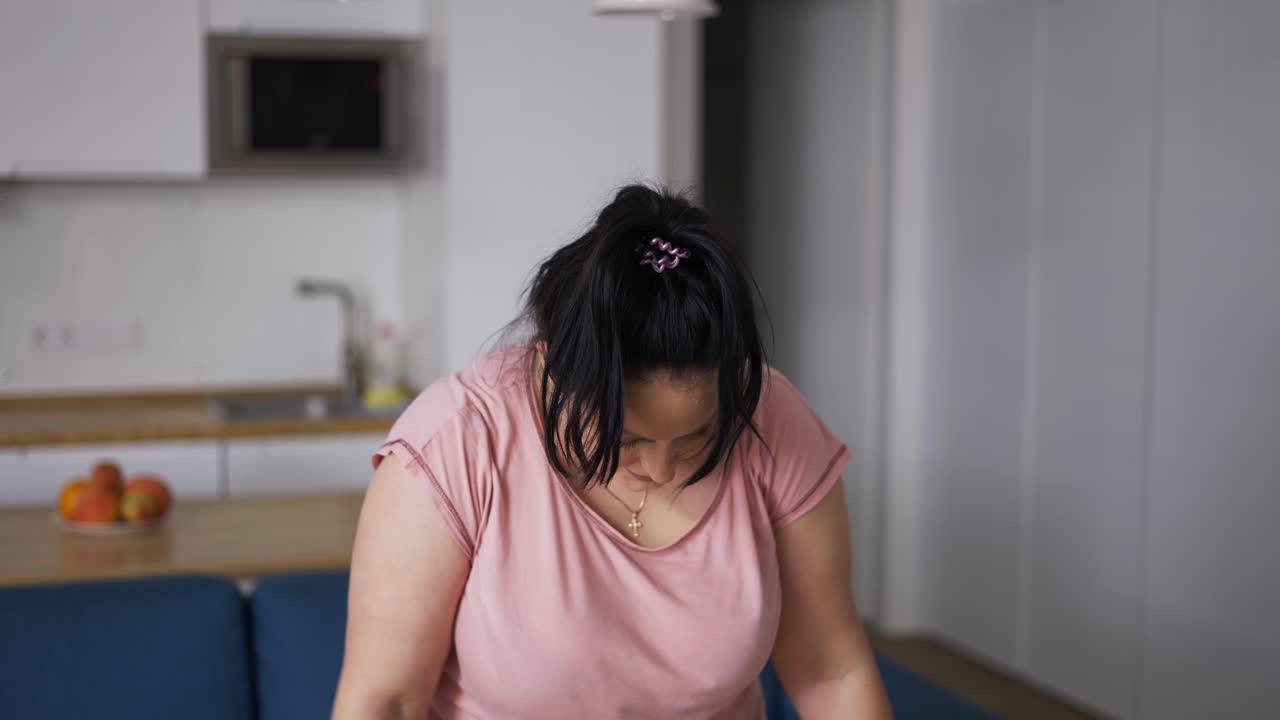 Giovane donna curvy attraente che si allena a casa.