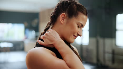 woman experiencing neck pain in a gym