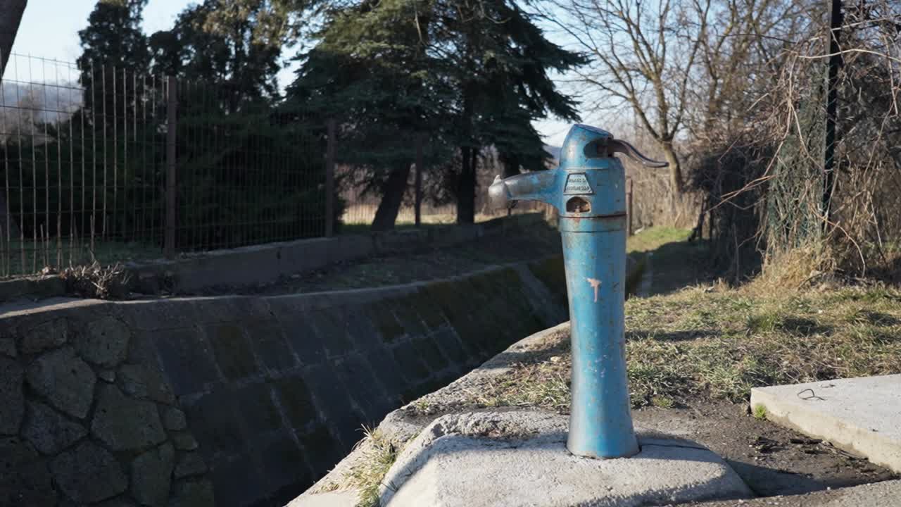 Old blue water pump in a rural area