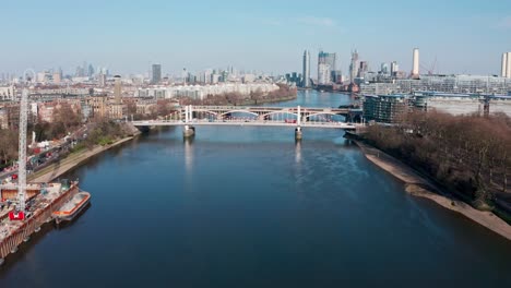 descending drone shot over london river thames at battersea power station chelsea bridge