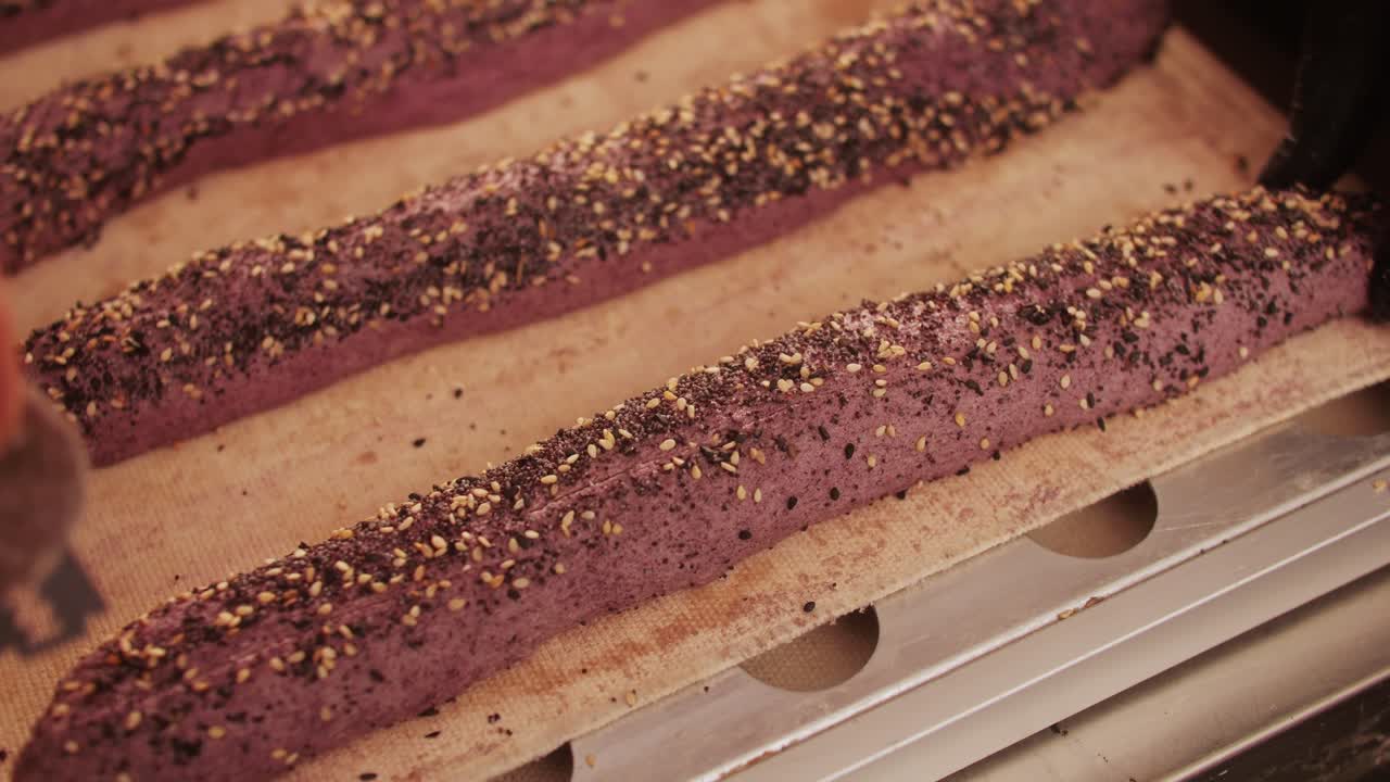 Bakery chef making different various of fresh Artesian buns and baguettes using traditional recipe close-up. Young man kneading dough. Artisan bread is making by skill bakers using natural and high-quality ingredients. Food with health and flavour benefits. Bakery shop and market