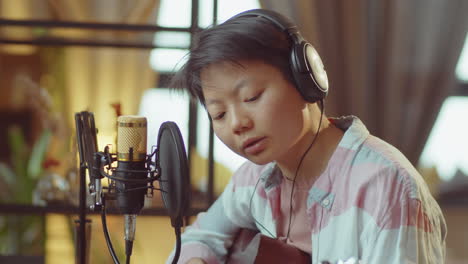 asian woman recording music in home studio