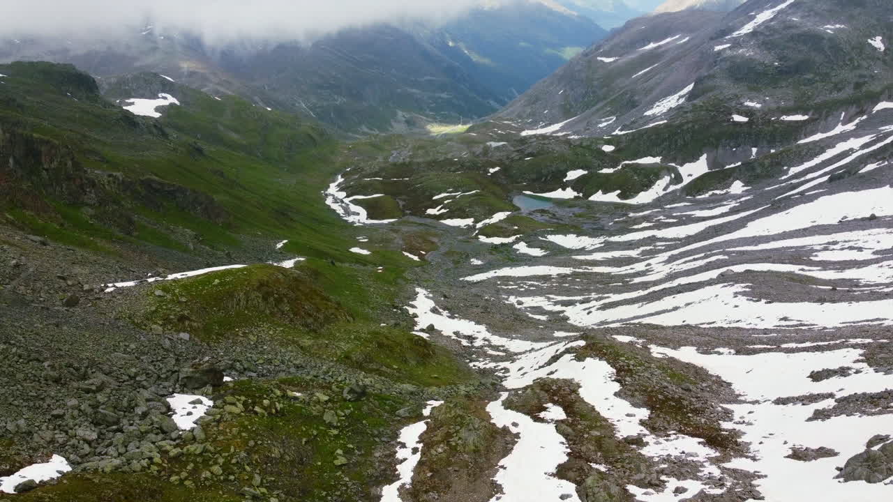 Veduta aerea dall'alto di un paesaggio di valle montana con neve che si scioglie a Zernez, Svizzera.