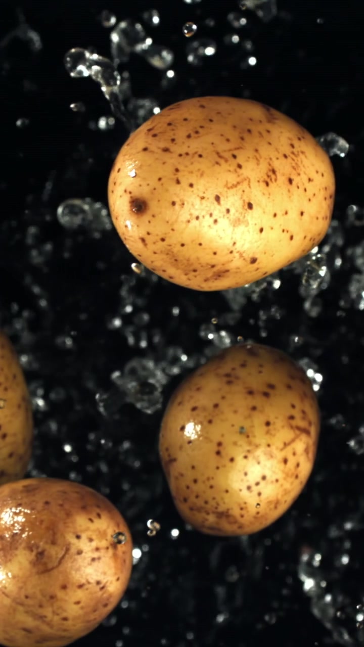 Movimento lento di acqua che schizza su patate crude