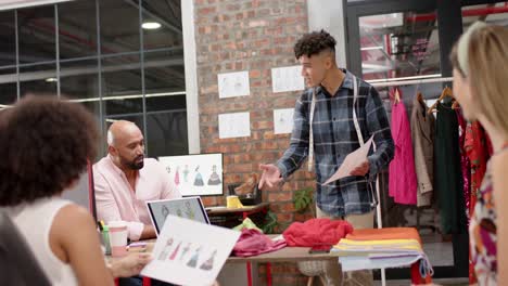 happy diverse female and male designers in design meeting at fashion studio, in slow motion