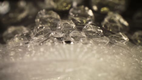 pushing into a bubble wrap bag, where the bag is really close to the lens as it cascades - rolls away as it moves through