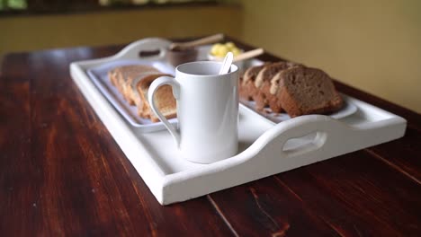 bread, butter and hot drink served on table awaiting someone to consume