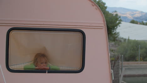 lonely caucasian 5-year-old girl contemplating in van