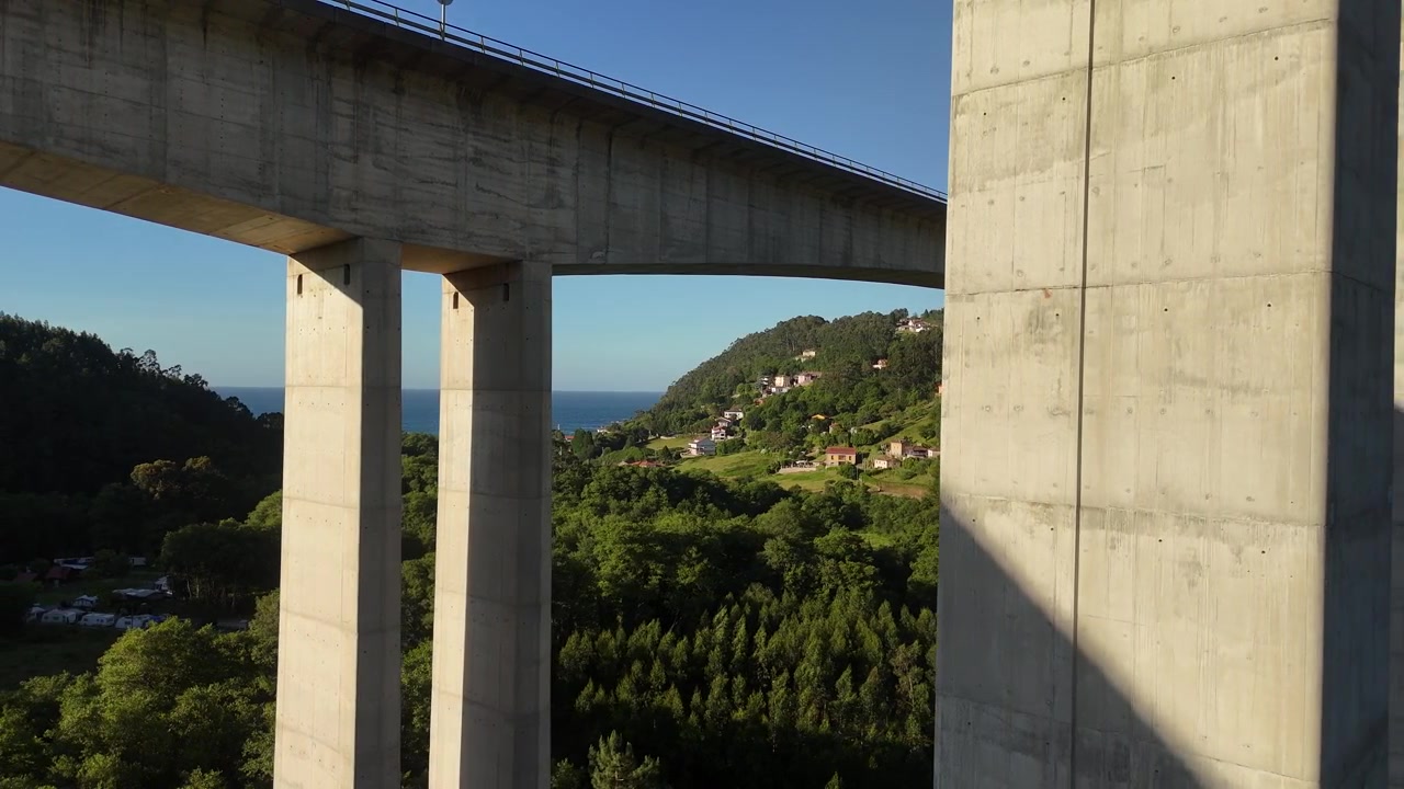 Vista de drone sob o viaduto La Concha de Artedo acima da floresta e do mar