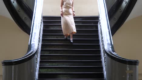 Close-up,-woman-makes-way-carefully-down-classical-luxury-staircase