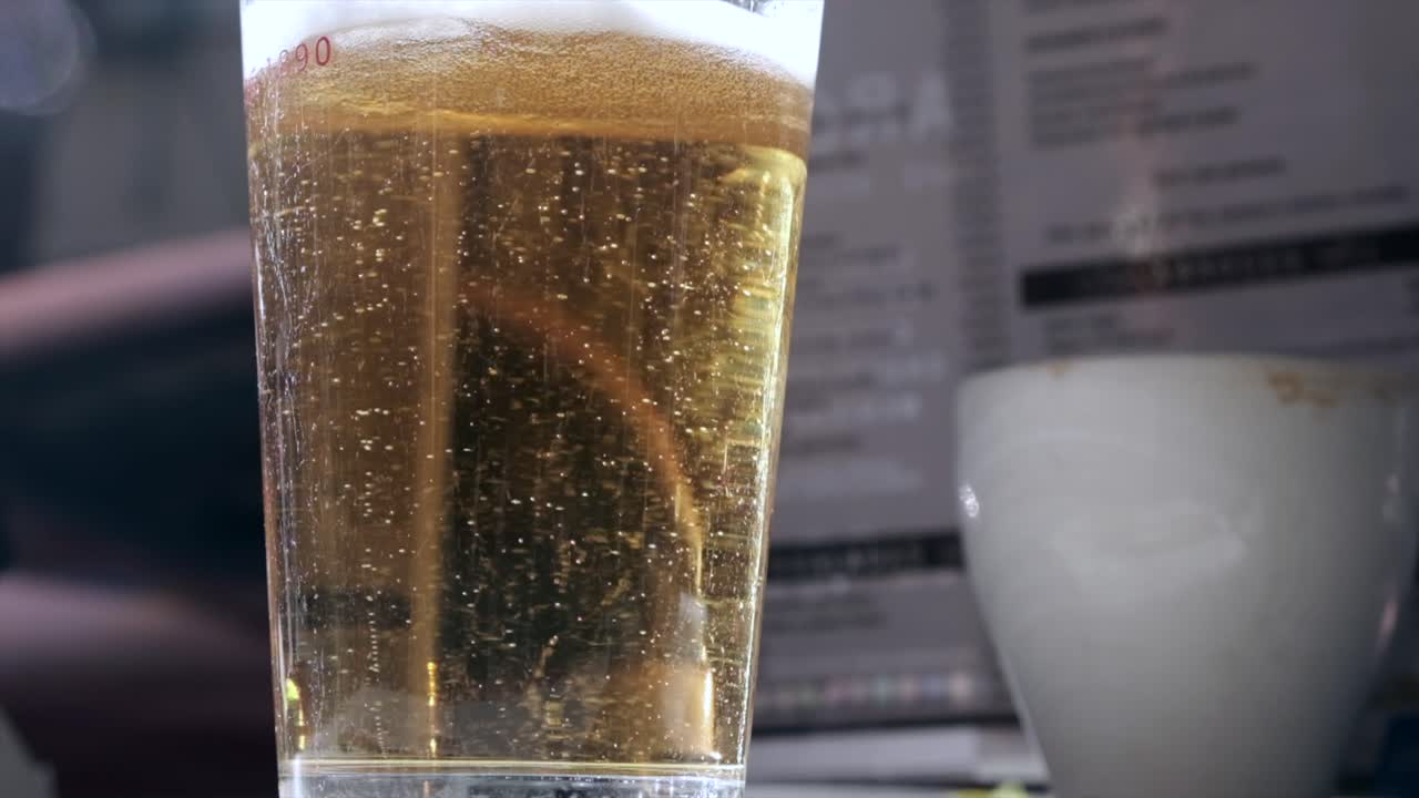 burbujas de cerveza en cámara lenta en un vaso en una mesa de bar