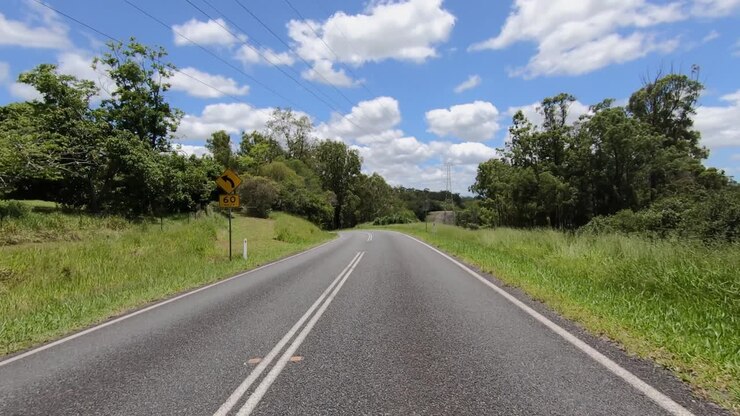 Rear facing driving point of view POV of a deserted Queensland country road with turn down dead straight lane - ideal for interior car scene green screen replacement