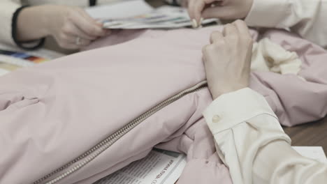 fashion design team working on a pink jacket