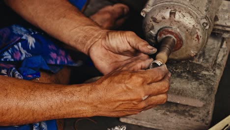 Close-up-of-Man-polishing-silver-ring-in-factory-workshop-in-rural-Bali,-Indonesia