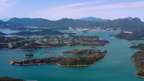 Camión-Aéreo-A-La-Derecha-Del-Embalse-De-La-Isla-Alta-Islotes-Verdes-Y-Colinas-Rodeadas-De-Agua-Turquesa,-Península-De-San-Kung-En-Hong-Kong,-China